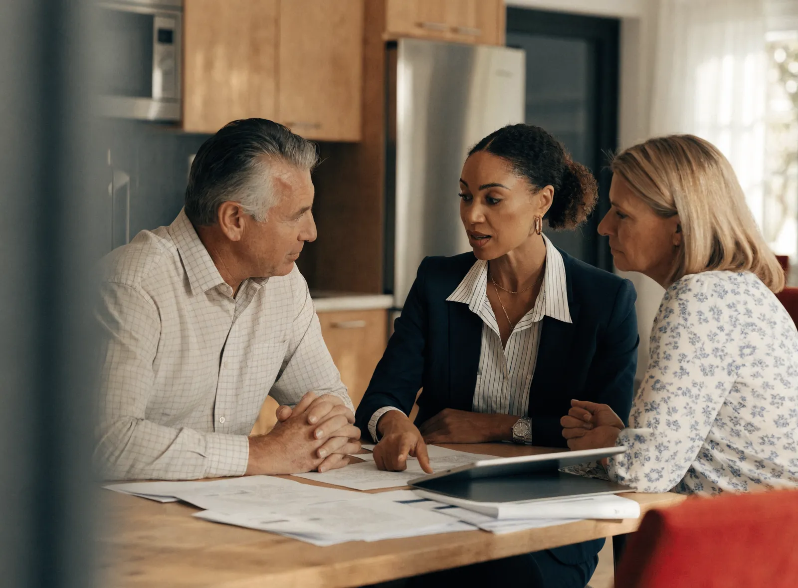 A professional public adjuster reviewing property-claim documents with a homeowner.